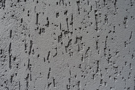 Closeup of ash gray wall with stucco worm finish