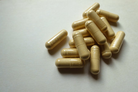 Fistful of beige capsules of Saccharomyces boulardii probiotic dietary supplementの写真素材