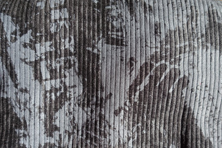 Surface of gray corduroy fabric with abstract print