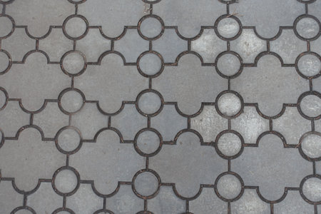 Top view of pavement of curved gray interlocking concrete tiles