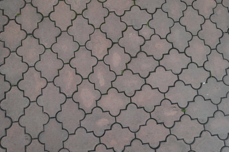 Background - pale pink pavement of interlocking concrete tiles with moroccan lattice layout
