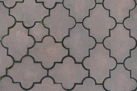 Top view of pale pink pavement of interlocking concrete tiles with moroccan lattice layout