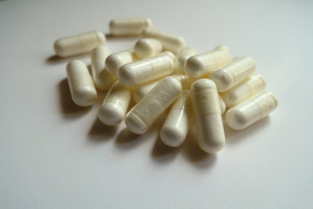 Close shot of fistful of white capsules of acetyl cysteine dietary supplement