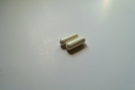 Pair of white capsules of acetyl cysteine dietary supplementの写真素材