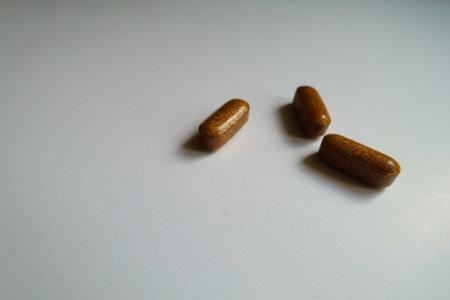 Closeup of three brown caplets of iron dietary supplement
