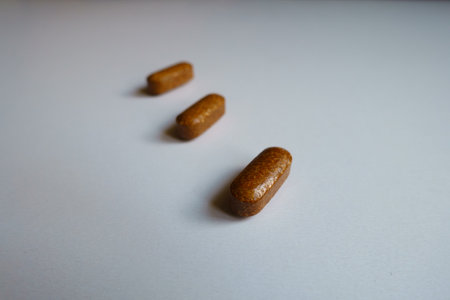 Close up of three brown caplets of iron dietary supplementの写真素材