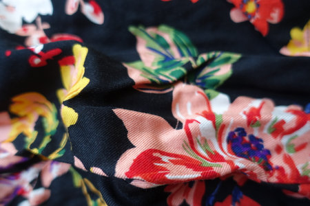 Rumpled black viscose fabric with colorful floral print