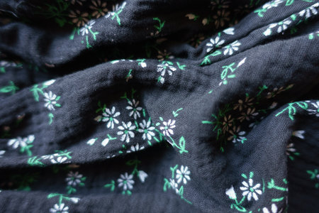 Soft folds on black cotton muslin fabric with floral printの写真素材