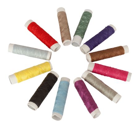 several colored spools of threads laid out in a circle