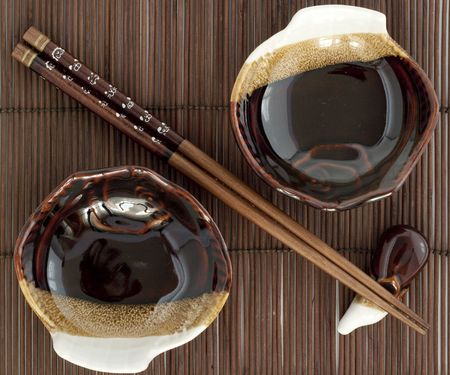 Sticks fo sushi and two porcelain plates on the brown bamboo matの写真素材