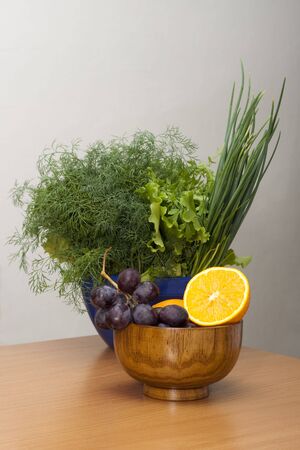 Bowl with fruits and bowl with green vegetablesの写真素材