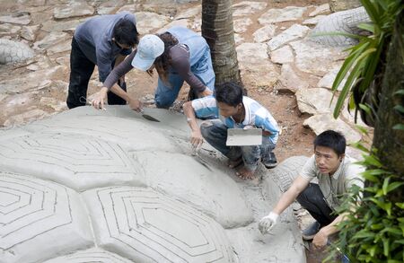 Four men made the turtle sculpture in a Nong Nooch tropical garden.のeditorial素材