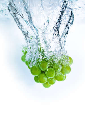 fresh grape dropped into water, isolated on white backgroundの写真素材
