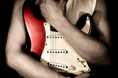 A man holding the red guitarの写真素材