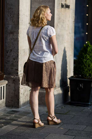 Munich, Germany - July 15, 2014  Young woman with long blond hair is walking in front of Dalmayer  famouse German Cafee Shop  in Munich  It s afternoon a beautiful summer day  のeditorial素材