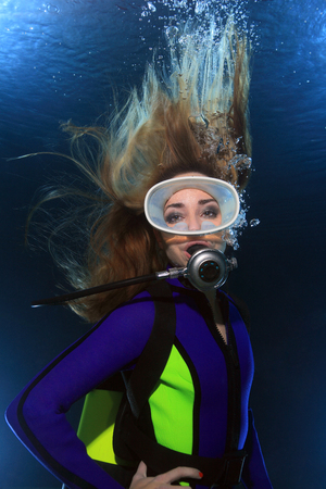 Scuba woman with long hair underwaterの写真素材