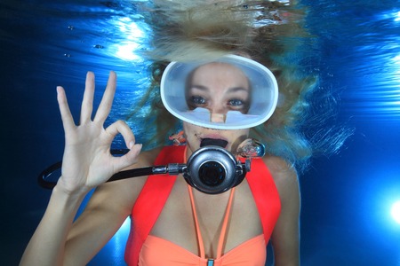Happy female scuba diver show underwater signal の写真素材