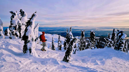 Man snowshoeing on mountains at sunset. Mount Seymour Provincial Park. Vancouver. British Columbia. Canada.の写真素材