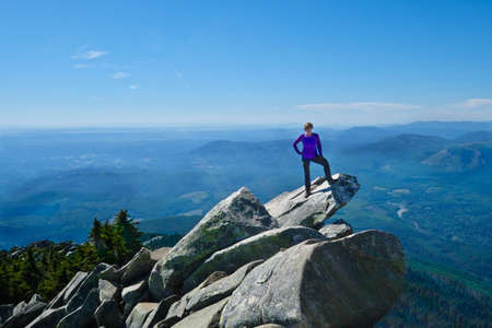 Woman in victory pose on mountain top. Mount Pilchuck. Cascades Mountains. Seattle. Washington....