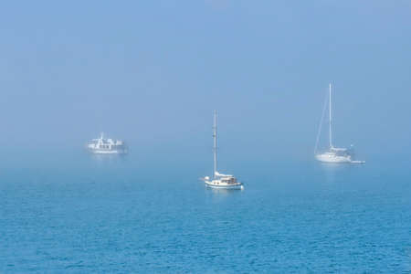 Boats in fog. Sailing boats moored on a misty harbor in Boston, Linconlnshire. United Kingdom.の写真素材