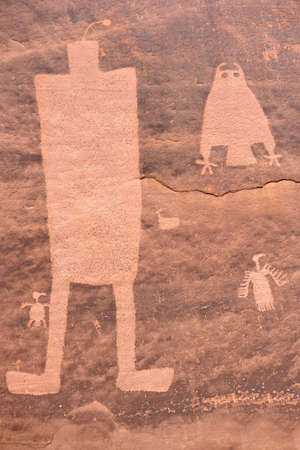 Prehistoric rock art of Pueblo Indians. Owl, thunderbird, goat and a man figure petroglyphs on sandstone wall near Moab in Utah. Moab. Utah. United States.の写真素材