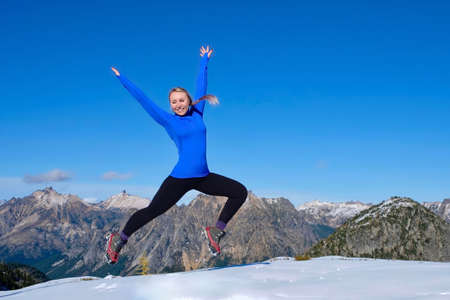 Young woman jumping with joy in mountains. Pacific Northwest.  Cascade Mountains near Seattle. Washington. United States of America.の写真素材