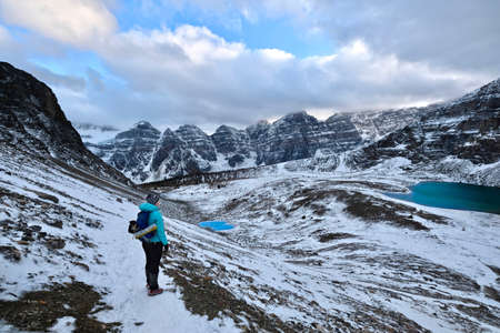 Hiking in Canadian Rockies. Woman hiker standing on Sentinel Pass and enjoying the views of Ten Peaks Valley and Minnestimma lake at the foot of Eiffel Peak. Banff National Park. Alberta. Canada.の写真素材