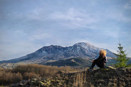 Woman sitting on rock in Mt St Helens National Volcanic Monument.  Hiking in Washington State.  United States of Americaの写真素材