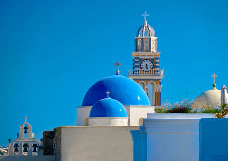Blue domes under blue sky  in Santorini island. White buildings and blue domes of greek church. Summer in Greece.の写真素材
