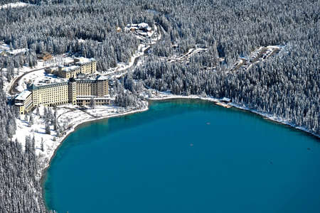 Lake Louise resort in Canadian Rockies. Blue alpine lake with boats and forest covered with fresh snow. Banff National Park. Alberta. Canadaの写真素材