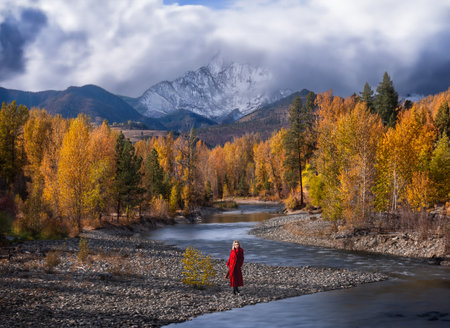 A woman in a red coat walks along the banks of the Wenatchee river. Washington. USAの写真素材