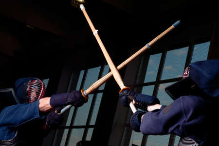 Kendo fighting with two bokkens, low key lightの写真素材