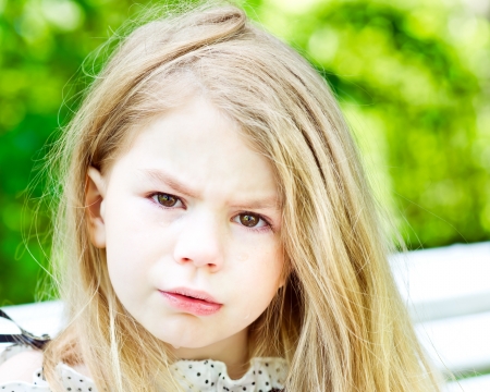 Adorable blond crying little girl with tears on her cheeksの写真素材