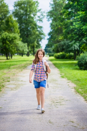 Pretty teenager girl in casual clothes going to school on sunny september day, outdoor portraitの写真素材