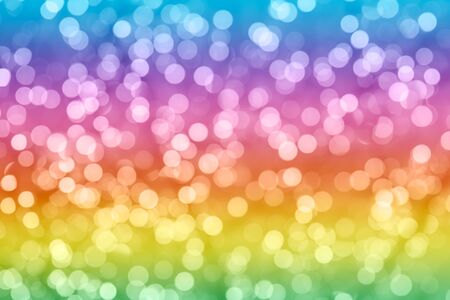 Rainbow colorful background with natural bokeh defocused sparkling lights. Bright and vivid texture with twinkling lightsの写真素材