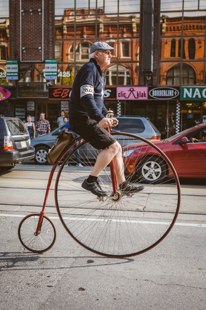 Toronto, Canada - September 20, 2014: Unidentified participants of Tweed Ride Toronto in vintage style clothes riding on their bicycles. This event is dedicated to the style of old Englandのeditorial素材