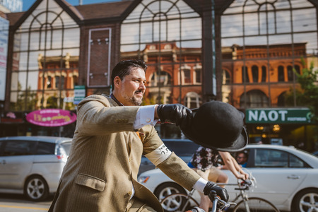 Toronto, Canada - September 20, 2014: Unidentified participants of Tweed Ride Toronto in vintage style clothes riding on their bicycles. This event is dedicated to the style of old Englandのeditorial素材