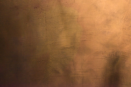 Old scratched and chapped painted gold and orange wall. Abstract textured colored background, empty templateの写真素材