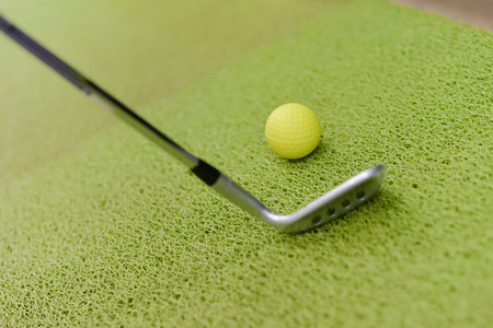 Golf club and ball on green indoor grass background. Closeup photoの写真素材
