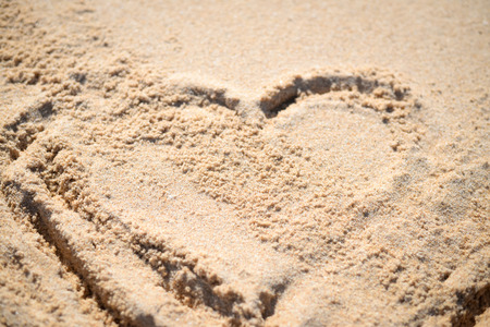 Love heart drawn on the sand of a beach backgroundの写真素材