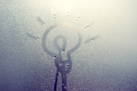 Lamp icon inscription on foggy window glass. Idea or ecology conceptの写真素材