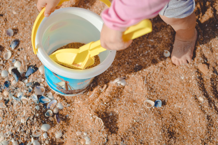 Joyful kid playing on the beach on sand copy space backgroundの写真素材