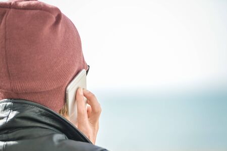 Woman talking on the phone on light outdoors background