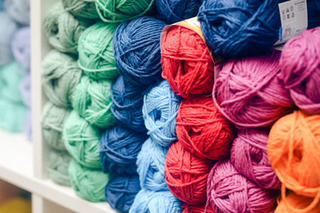 Colorful balls of wool or cotton yarn piled up on shop shelfの写真素材