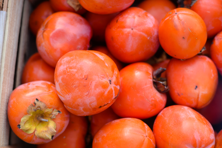 Persimmon kaki fruits freshly collected at the market boxesの写真素材