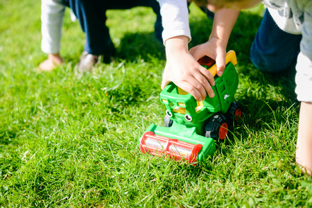 Kids playing with toys combine harvester on sunny outdoors background. Happy playful harvest timeの写真素材