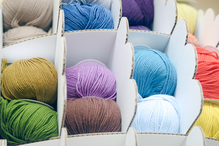 Colorful balls of wool or cotton yarn piled up on shop shelfの写真素材