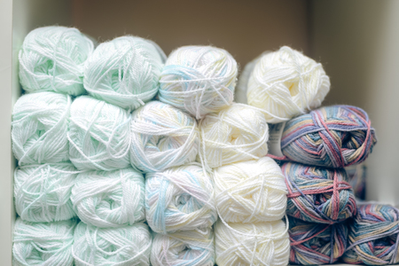 White balls of wool or cotton yarn piled up on shop shelf, closeupの写真素材