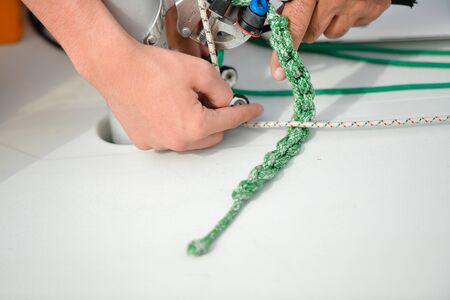 Closeup on hands tie a rope on the boat yacht background.