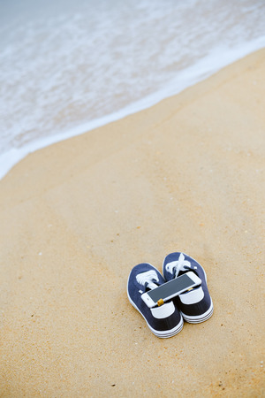 Closeup on smartphone on the beach background. Top view flat lay styleの写真素材